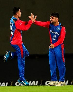 Afghanistan`s Mujeeb Ur Rahman (L) celebrates with captain Rashid Khan (R) after the dismissal of Bangladesh`s captain Shakib Al Hasan during the third match between Afghanistan and Bangladesh in the T20 Tri-nations cricket series at the Sher-e-Bangla National Stadium in Dhaka on 15 September, 2019. Photo: AFP