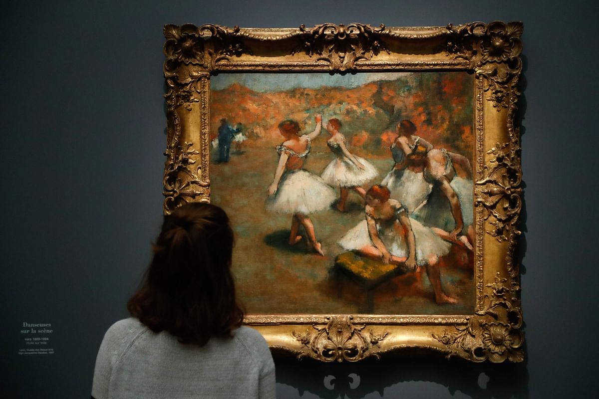 A person looks at the painting entitled `Dancers on stage` (Danseuses sur la scene) made around 1889 and 1894 by French painter Edgar Degas, during the press visit of the exhibition `Degas at the Opera` at the Museum of Orsay, in Paris, on 20 September 2019 in Paris. Photo: AFP