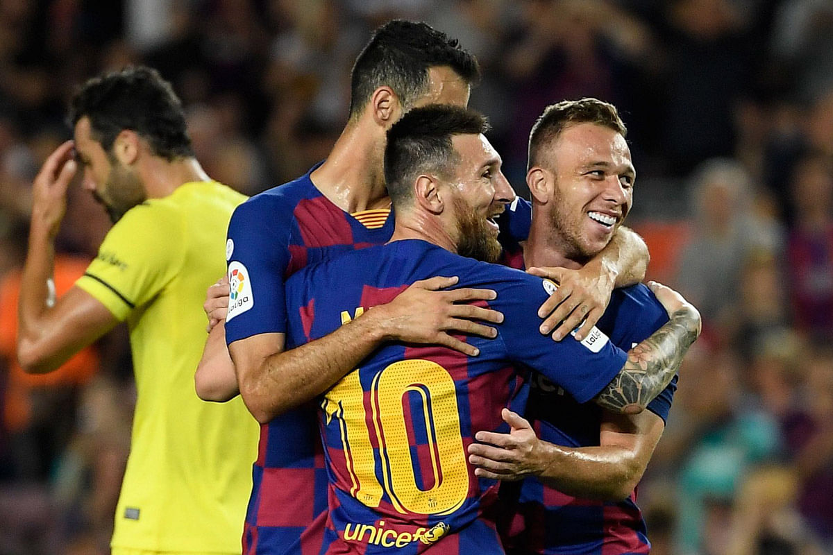 Barcelona`s Brazilian midfielder Arthur (R) is congratulated by teammate Barcelona`s Argentine forward Lionel Messi (C) after scoring the second goal during the Spanish league football match between FC Barcelona and Villarreal CF at the Camp Nou stadium in Barcelona, on Tuesday. Photo: AFP