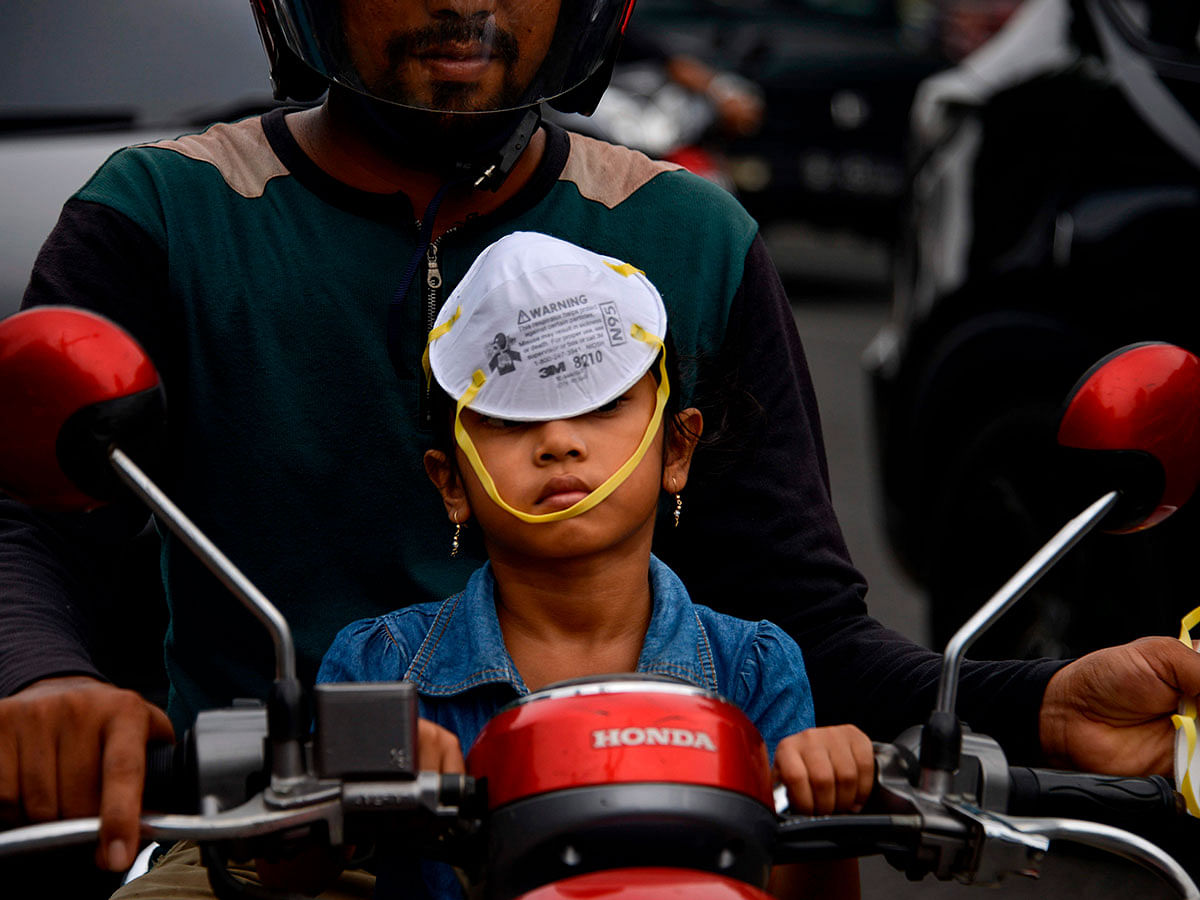 A child wears a facemask on her head as a thick haze blankets the sky over Banda Aceh on 24 September 2019, caused when Indonesian farmers use illegal slash-and-burn techniques to clear land for agriculture, spewing toxic haze across Southeast Asia. Photo: AFP