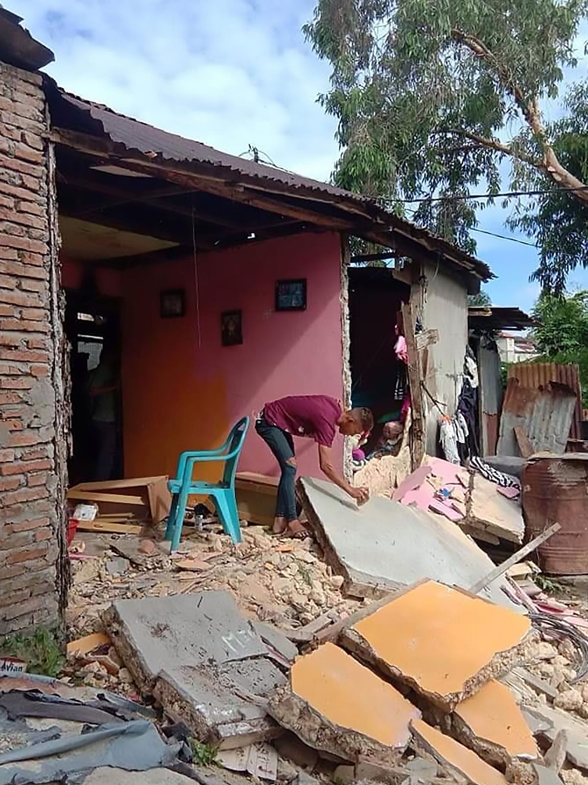 A resident inspects a collapsed wall of his house in Ambon, Indonesia`s Maluku islands, on 26 September 2019, following a 6.5-magnitude earthquake on 26 September 2019. Photo: AFP