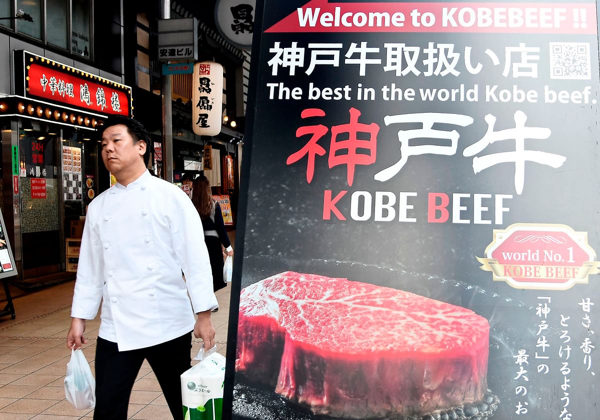 A man walk past a poster showing beef in the center of Kobe, Japan on 23 September 2019. Photo: AFP