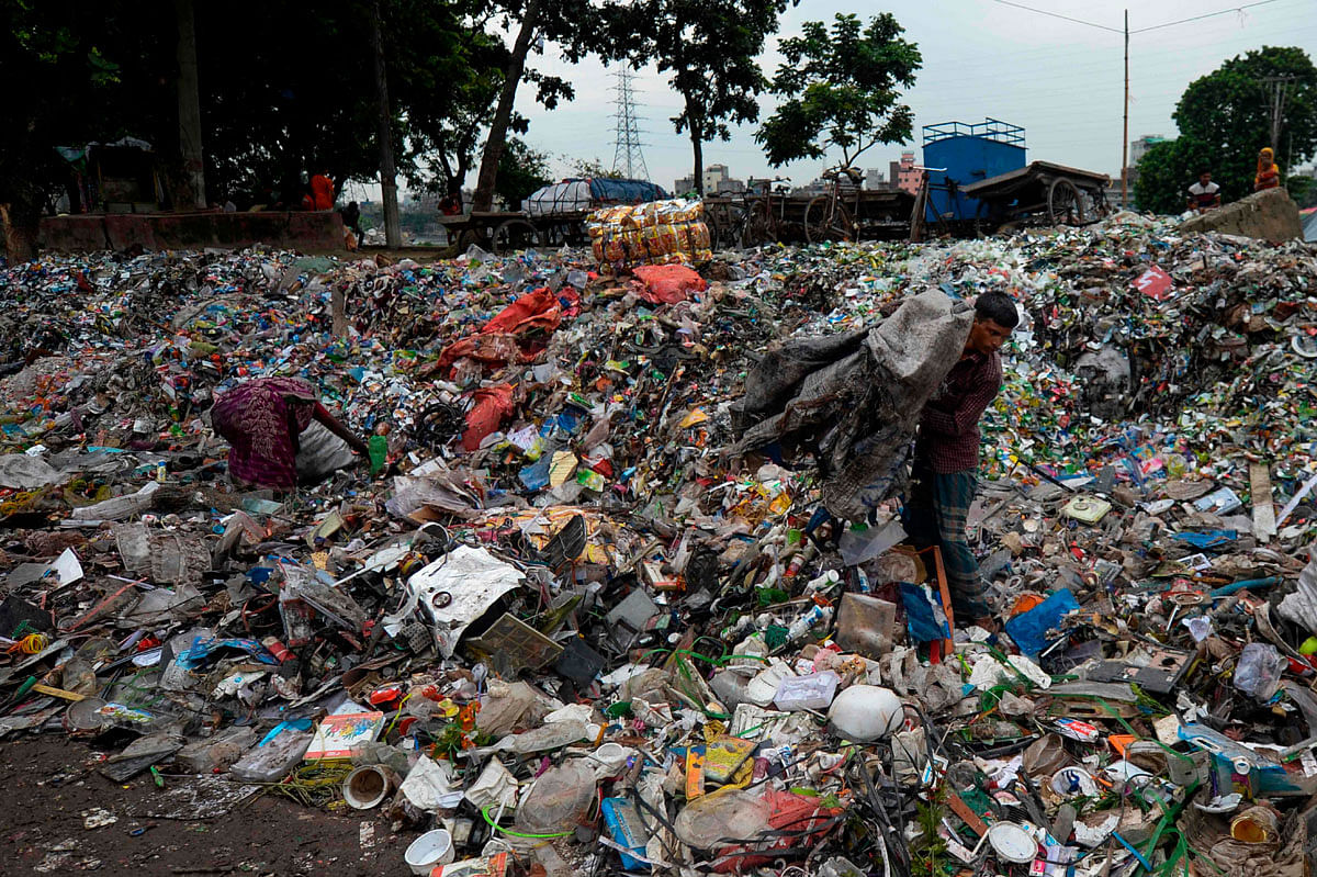 A Bangladeshi man collects objects from a garbage dump near the Buriganga river on 26 September, 2019. Photo: AFP