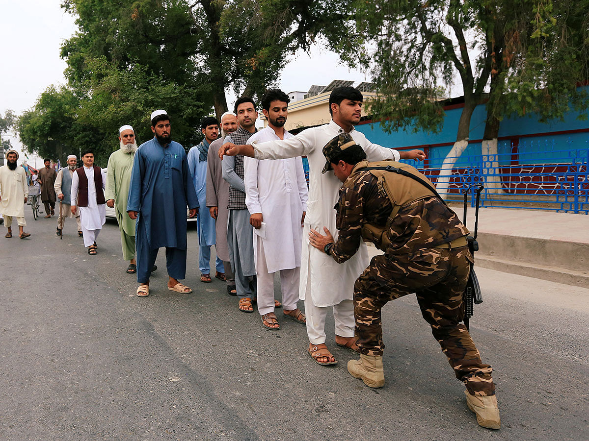 An Afghan security force officer inspects voters during the presidential election in Jalalabad, Afghanistan on 28 September 2019. Photo: Reuters