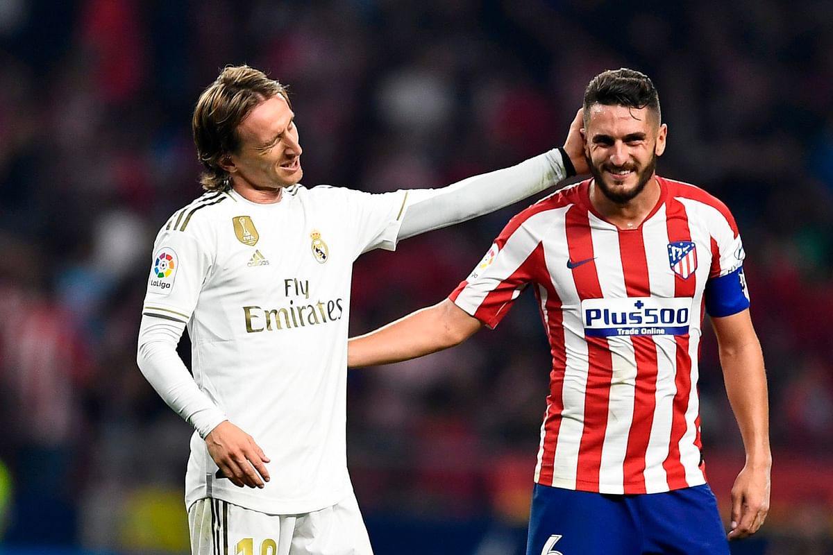 Real Madrid`s Croatian midfielder Luka Modric (L) speaks to Atletico Madrid`s Spanish midfielder Koke (R) at the end of the Spanish league football match between Club Atletico de Madrid and Real Madrid CF at the Wanda Metropolitano stadium in Madrid on Saturday. Photo: AFP