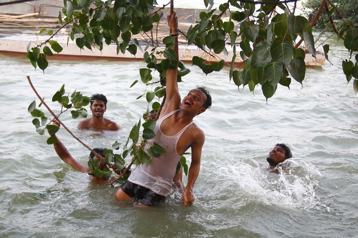 Indian youths swim in flood waters on the banks of the River Ganges as the water level of the Ganges and Yamuna rivers rises near the Sangam area in Allahabad on 22 September 2019. Photo: AFP