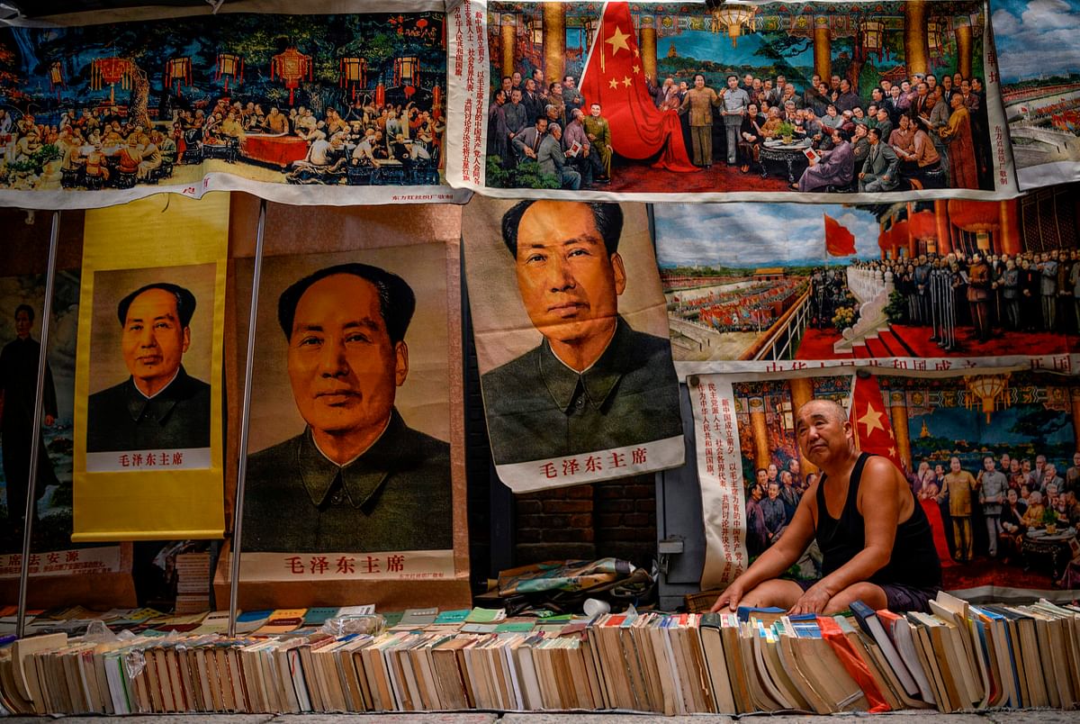 This picture taken on 7 September shows a vendor of books and souvenirs, some featuring Mao Zedong, waiting for customers at the Panjiayuan Antique Market in Beijing. Photo: AFP