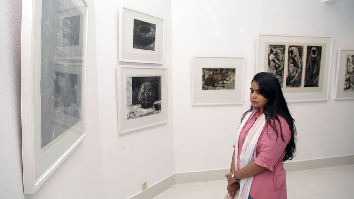 A visitor looks at print works at the solo art exhibition `Transformation` at Alliance Française de Dhaka on Friday. Photo: Prothom Alo