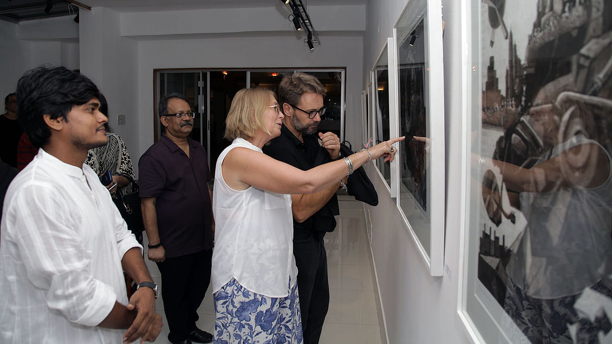 Visitors look at print works at the solo art exhibition `Transformation` at Alliance Française de Dhaka on Friday. Photo: Prothom Alo