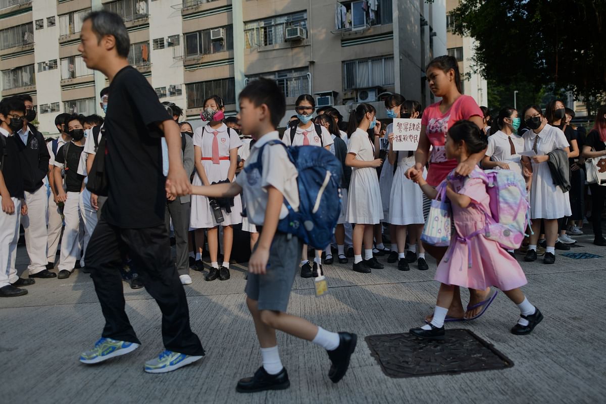 Schoolgoing children (foreground) are accompanied by their guardians as schoolmates of form five student Tsang Chi-kin, 18, who was shot in the chest by police during violent pro-democracy protests that coincided with China`s 1 October National Day, gather for a protest at a school in Hong Kong on 2 October 2019. Photo: AFP