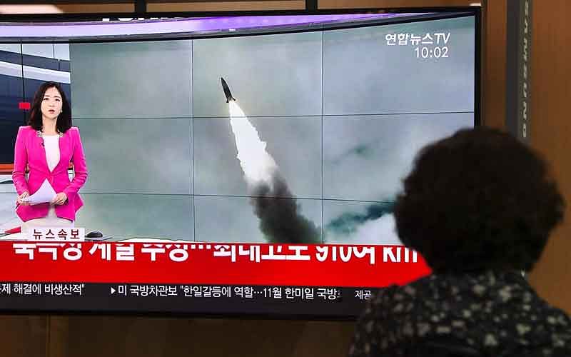 A woman watches a television news screen showing file footage of a North Korean missile launch, at a railway station in Seoul on 2 October. Photo: AFP