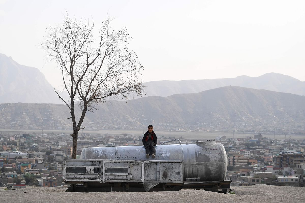 An Afghan child sits on a water tank at Nadir Khan hill in Kabul on 1 October 2019. Photo: AFP