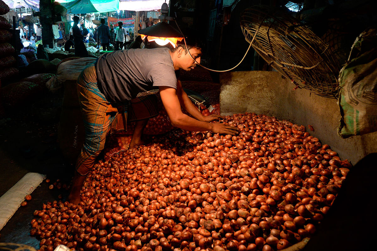 A salesman prepares onions at Kawran Bazaar wholesale market in Dhaka on 2 October 2019. Onion prices have rocketed in Bangladesh after India banned its export over local shortages, forcing the government to import the vegetable from other countries and sell it at subsidised prices. Photo: AFP