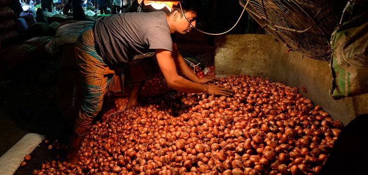 A salesman with onions at Kawran Bazar wholesale market in Dhaka on 2 October 2019. 