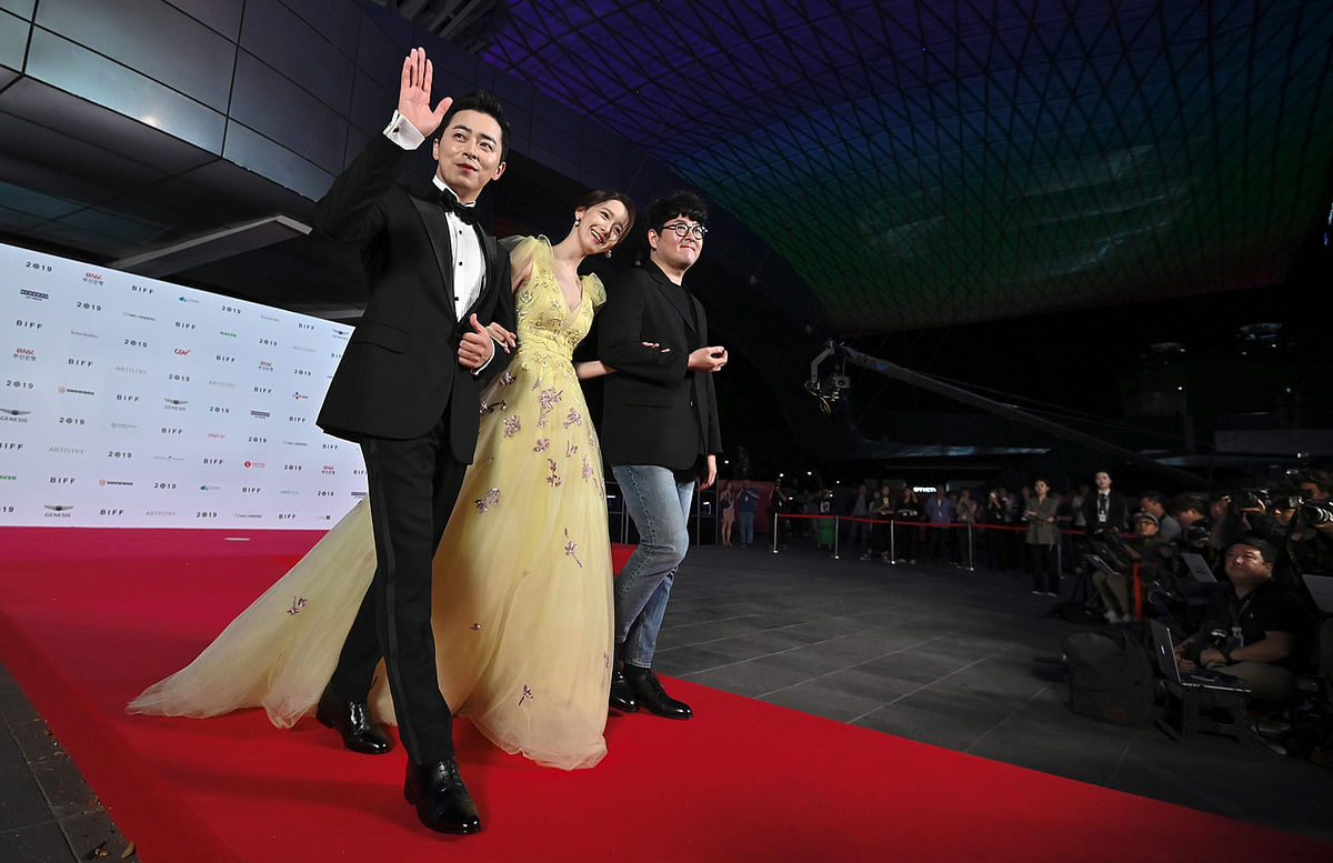 South Korean singer and actress Im Yoon-ah (C) walks with actor Jo Jung-suk (L) and director Lee Sang-geun (R) on the red carpet during the opening ceremony of the Busan International Film Festival (BIFF) at the Busan Cinema Centre in Busan on 3 October, 2019. Photo: AFP