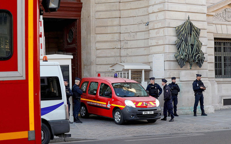 Police officers watch as a firefighter truck exits Paris prefecture de police (police headquarters) on 3 October 2019 after four officers were killed in a knife attack. A knife-wielding man working at police headquarters in central Paris went on a rampage on 3 October stabbing and killing four employees before himself being shot dead, officials said. Photo: AFP