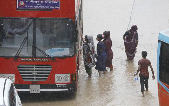 A few women try to get into a BRTC bus as water logged due to around 40-minute rain in Motijheel area, Dhaka on 1 October. Photo: Dipu Malakar