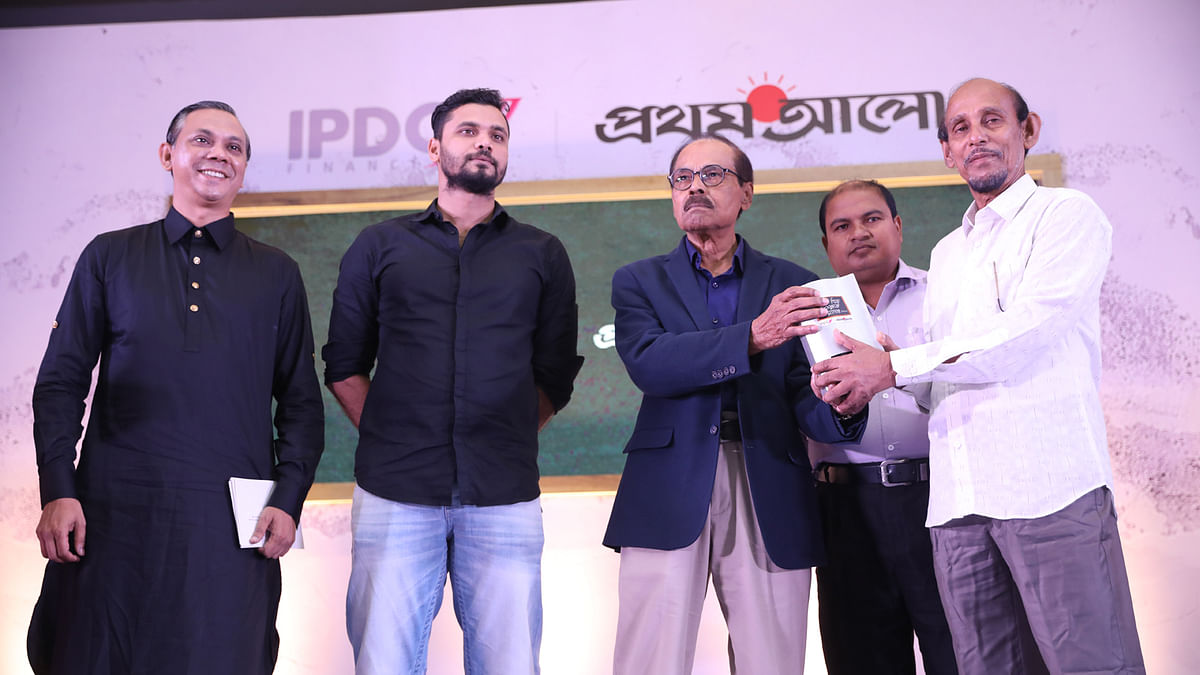 Abdus Salam, former teacher of Satkhira’s 30 number government primary school, receives award from singer Syed Abdul Hadi.