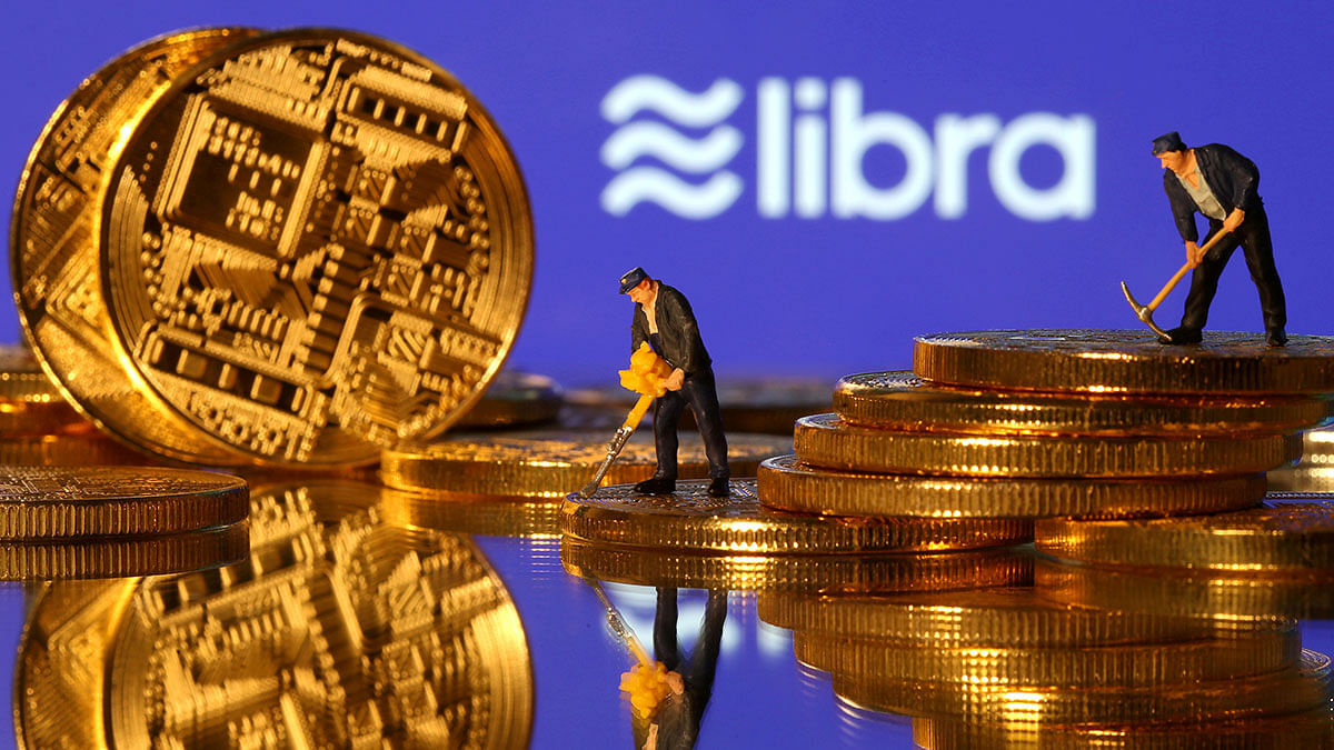 Small toy figures are seen on representations of virtual currency in front of the Libra logo in this illustration picture, 21 June 2019. Photo: Reuters