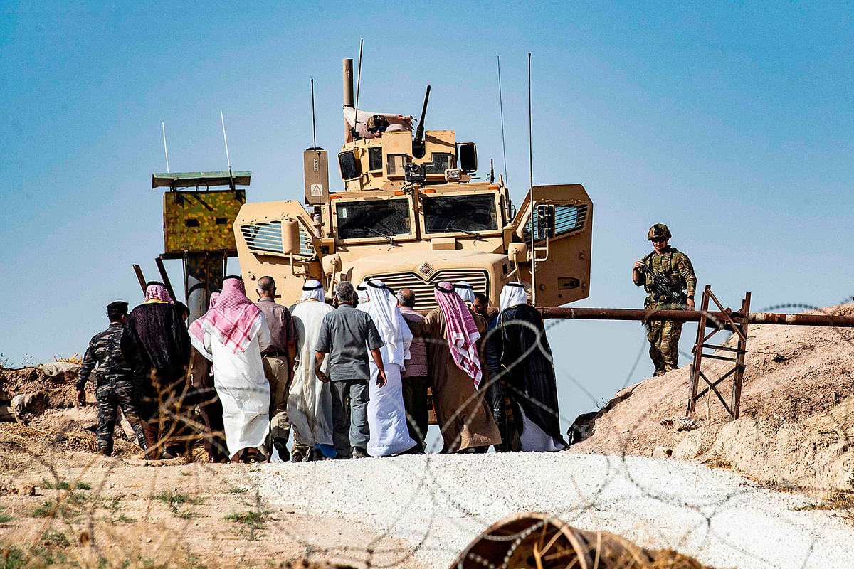 Syrian Kurds take part in a demonstration against Turkish threats at a US-led international coalition base on the outskirts of Ras al-Ain town in Syria`s Hasakeh province near the Turkish border on 6 October 2019. Photo: AFP