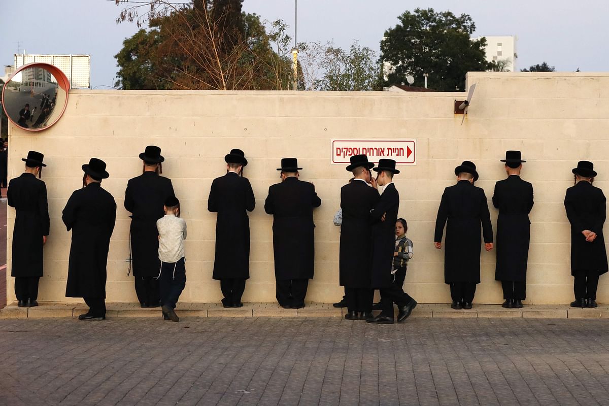 Ultra-Orthodox Jewish men pray along a wall in the Israeli city of Ramat Gan, near Tel Aviv, while performing the `Tashlich` ritual on 7 October 2019 during which `sins are cast into the water to the fish`. Photo: AFP