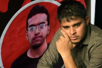 A Bangladeshi student sits during a protest in Dhaka on 7 October 2019, next to a portrait of Abrar Fahad, who was allegedly beaten to death by ruling party activists. Photo: AFP