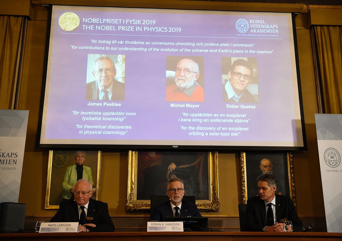 Members of the Nobel Committee for Physics (Bottom L-R) Chair of the Nobel Committee Mats Larsson, Secretary General of the Academy Goran K Hansson, and Ulf Danielsson sit in front of a screen displaying the portraits of the winners of the 2019 Nobel Prize in Physics (Up L-R) Canadian-American James Peebles, Swiss scientists Michel Mayor and Didier Queloz, at the Royal Swedish Academy of Sciences on 8 October 2019 in Stockholm. Photo: AFP