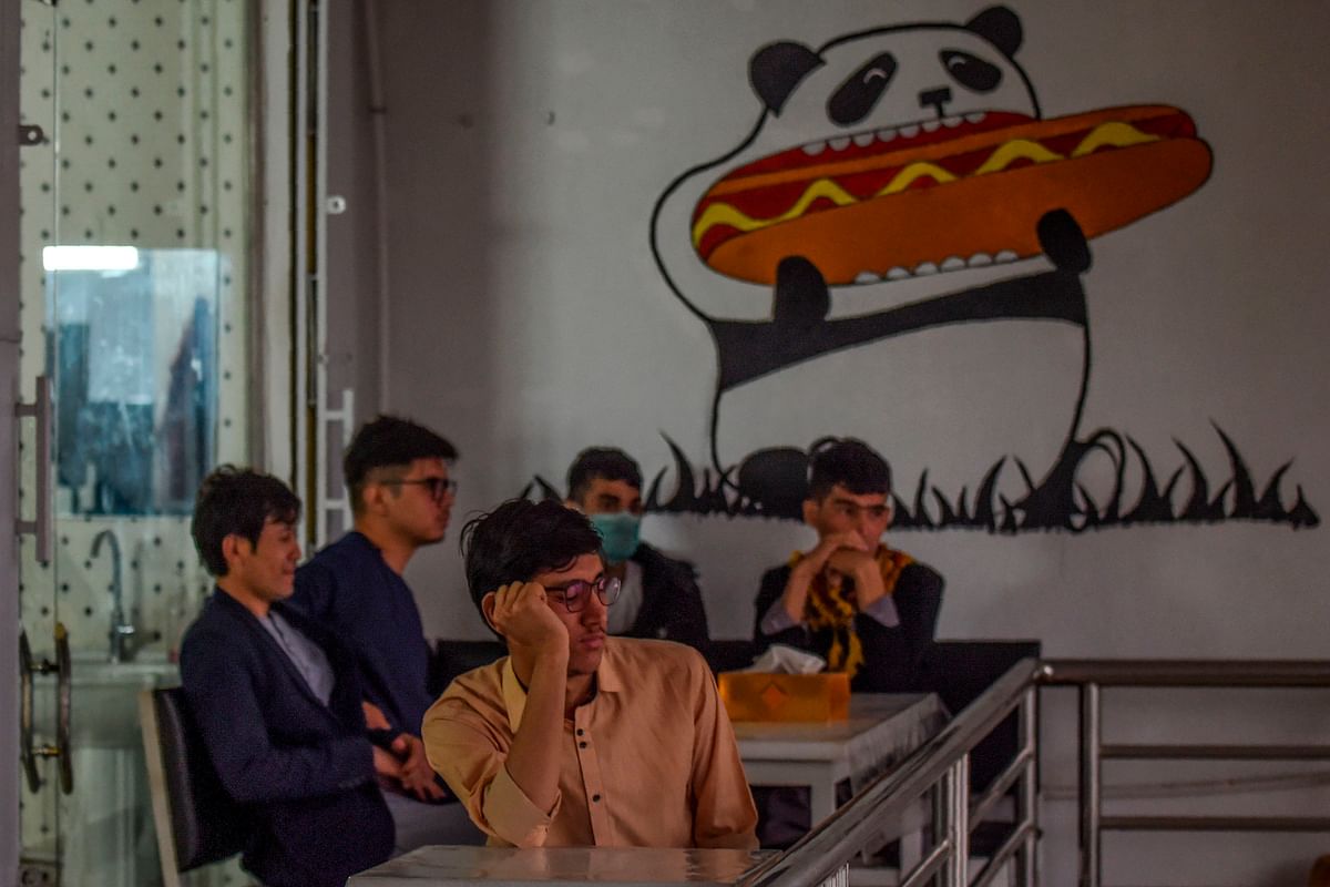 Youths look on as they sit on the terrace of a fast food restaurant in Kabul on 6 October 2019. Photo: AFP