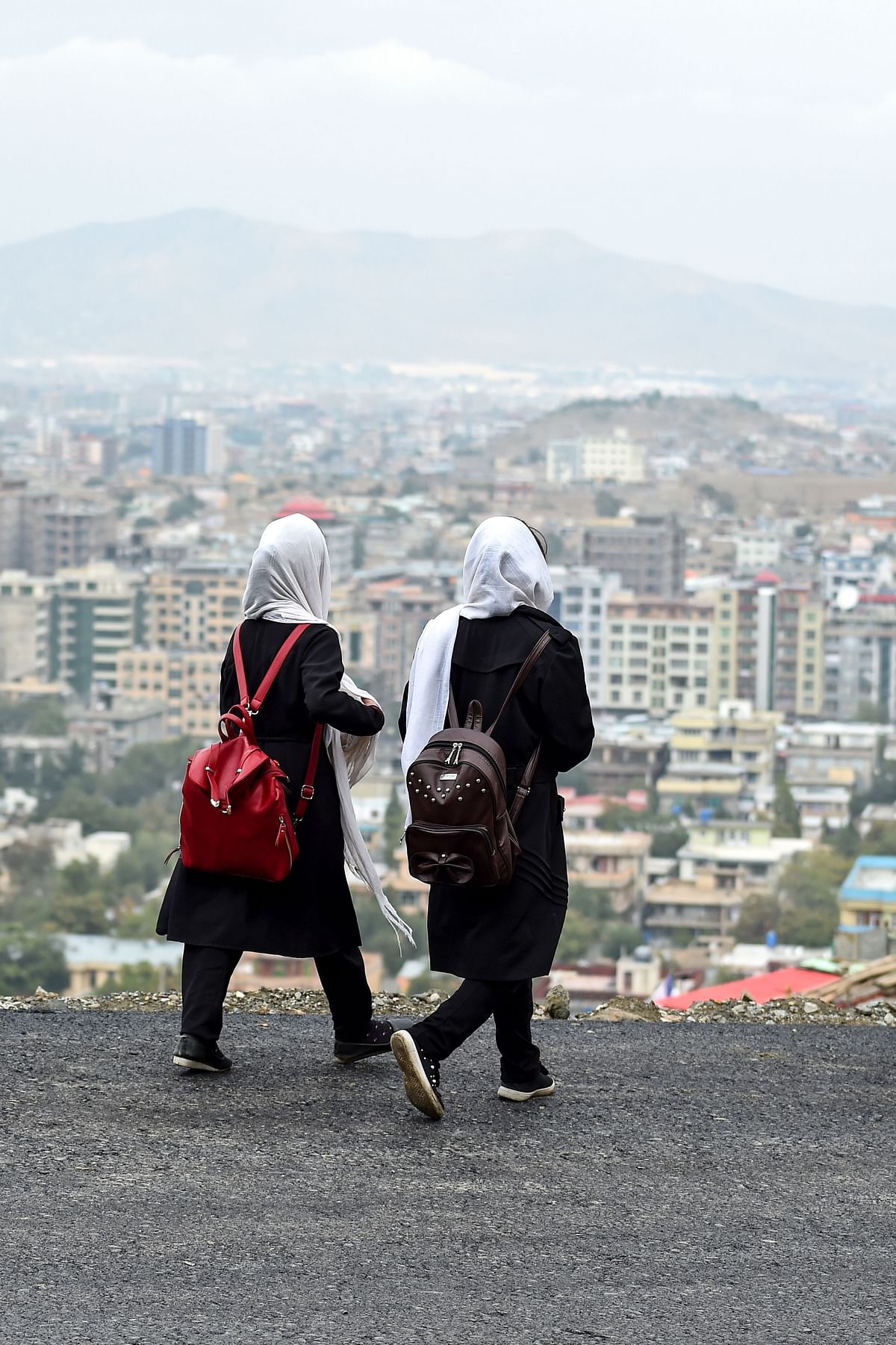 Schoolgirls walk along a street at a hillside overlooking Kabul on 6 October 2019. Photo: AFP