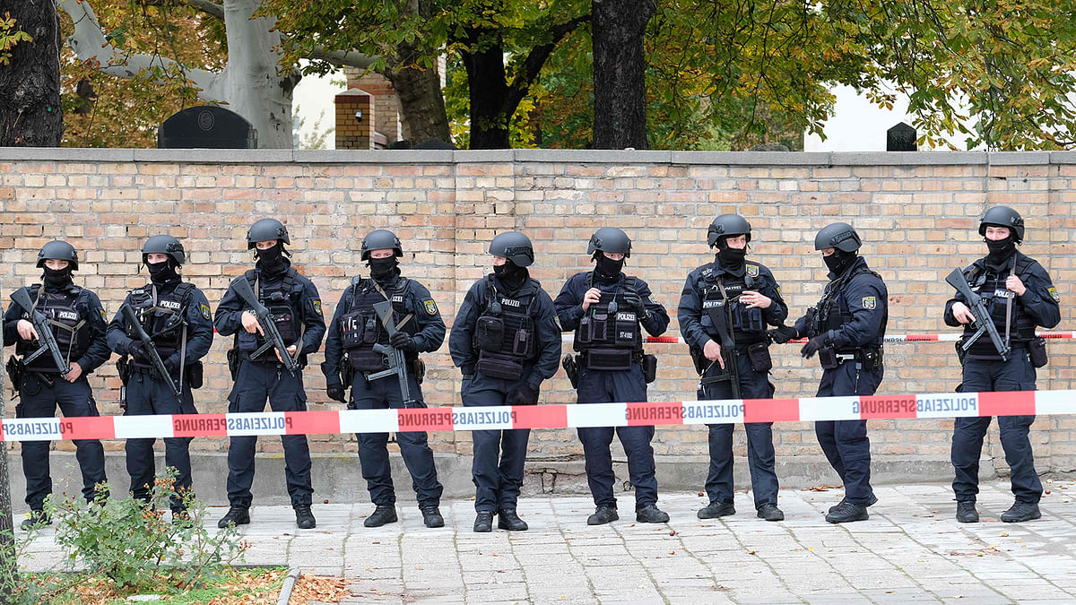 Policemen stand in front of a wall of the Jewish cemetery close to the site of a shooting in Halle an der Saale, eastern Germany, on 9 October 2019. At least two people were shot dead on 9 October 2019 on a street in Halle, police said, with witnesses saying that the synagogue was among the gunmen`s targets as Jews marked the holy day of Yom Kippur. Photo: AFP