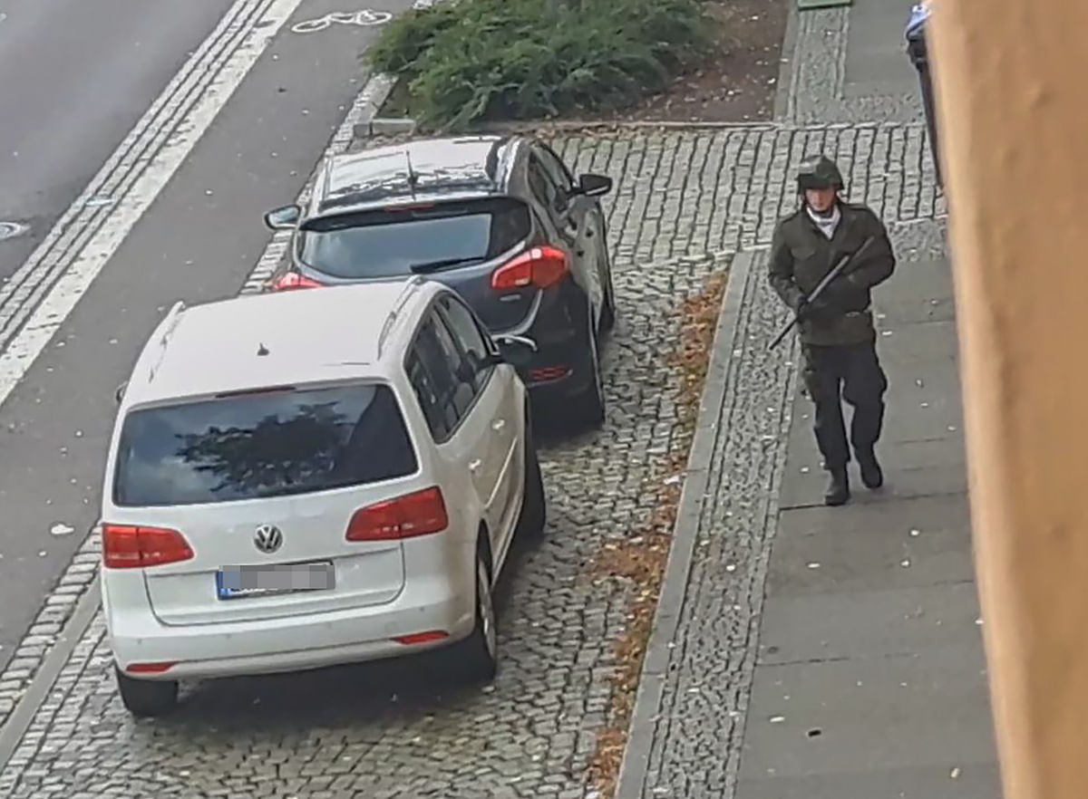 In this screenshot taken from a video by ATV-Studio Halle, a man walks with a gun in the streets of Halle an der Saale, eastern Germany, on 9 October 2019. Photo: AFP