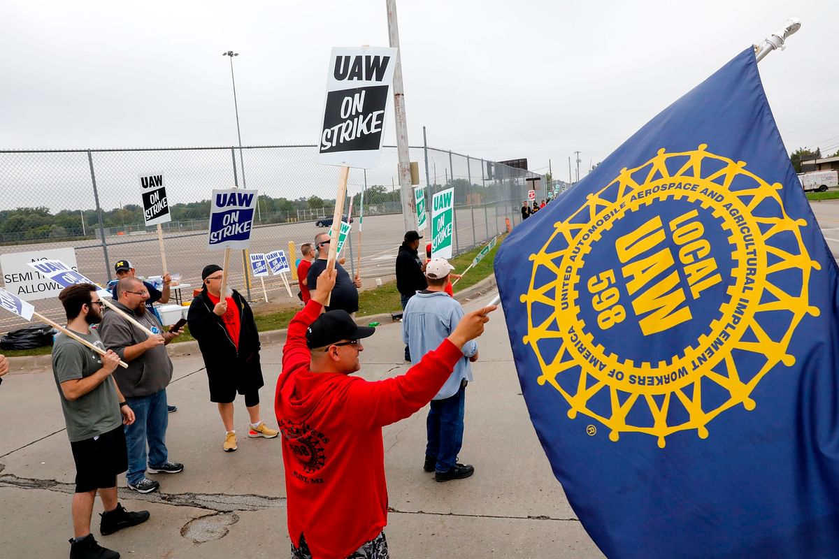 In this file photo taken on 16 September 2019 David Garcia (C) (holding a United Auto Workers (UAW) flag) who is employed at the General Motors Co. Flint Assembly plant in Flint, Michigan, pickets outside of the plant during a strike. Photo: AFP