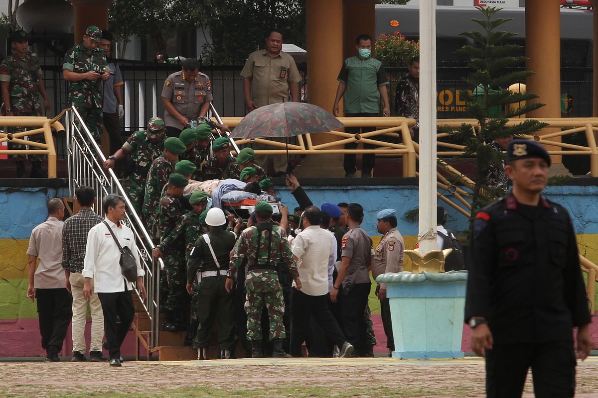 Indonesian police and military carry Indonesia`s Security Minister Wiranto (C) to a helicopter to be medevaced after he was stabbed in Pandeglang, Banten province, on 10 October 2019. Photo: AFP