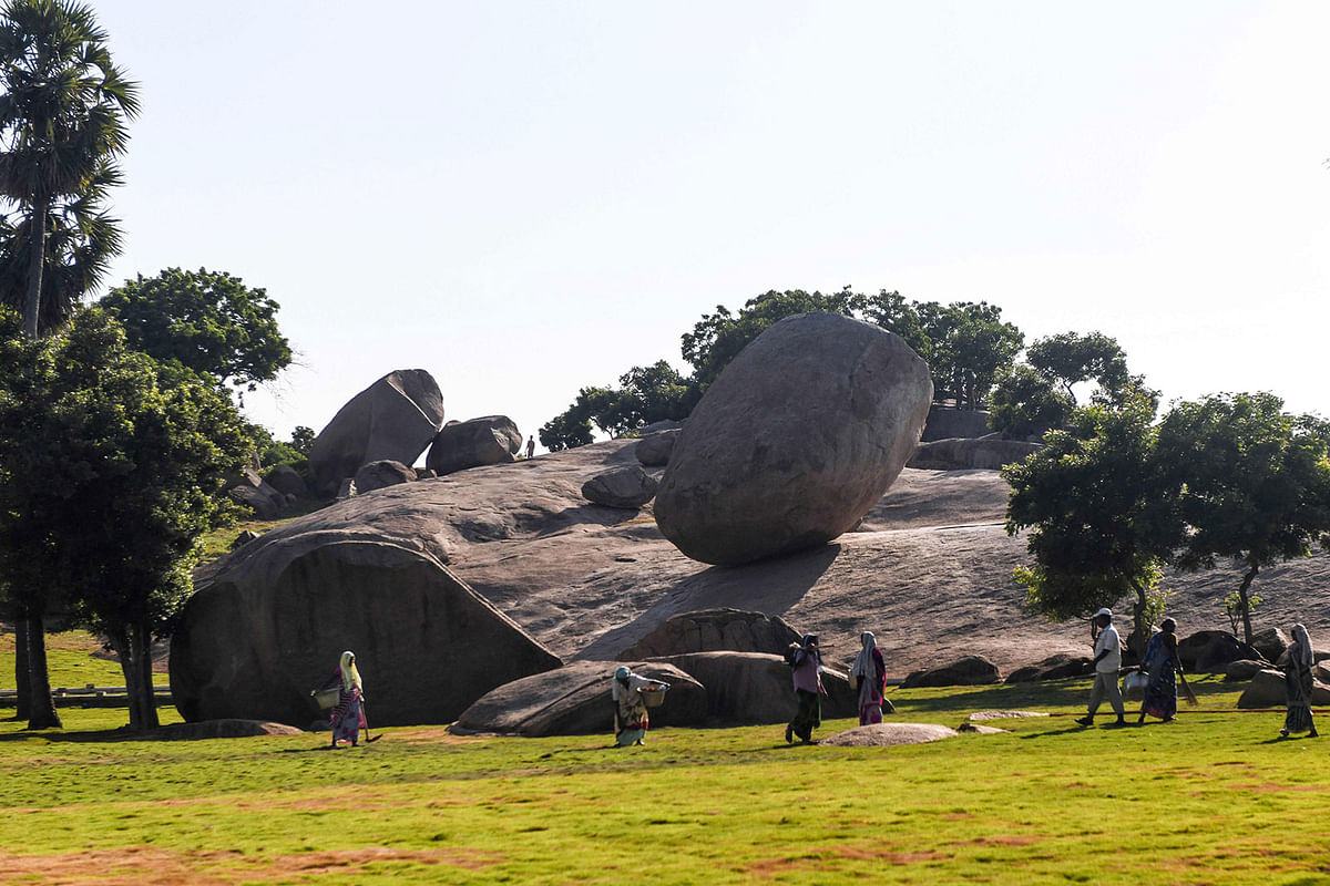 Labourers work in a garden beside the granite boulder `Krishna`s Butterball` at Mahabalipuram on 10 October 2019, ahead of a summit between India`s prime minister Narendra Modi and China`s president Xi Jinping held at the World Heritage Site of Mahabalipuram from 11 to 13 October in Tamil Nadu state, India. Photo: AFP
