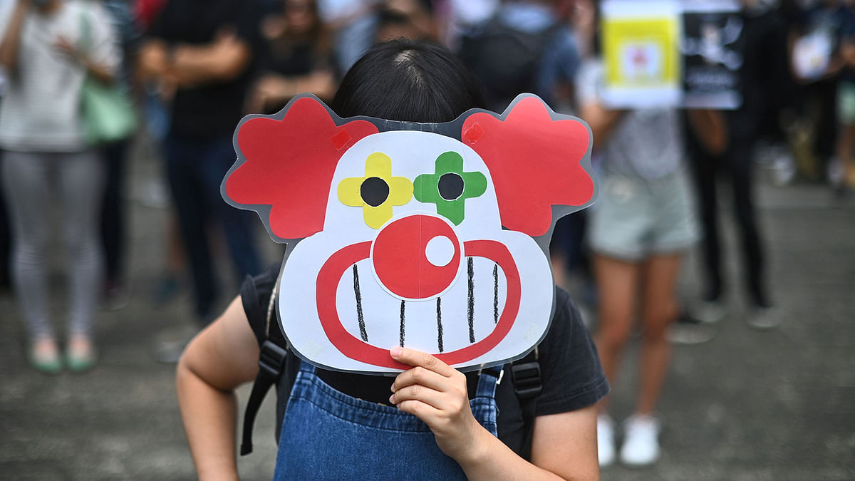 A demonstrator holds a clown mask during a flash mob rally to show support for pro-democracy protesters at Chater Garden in the Central district in Hong Kong on 11 October 2019. Photo: AFP