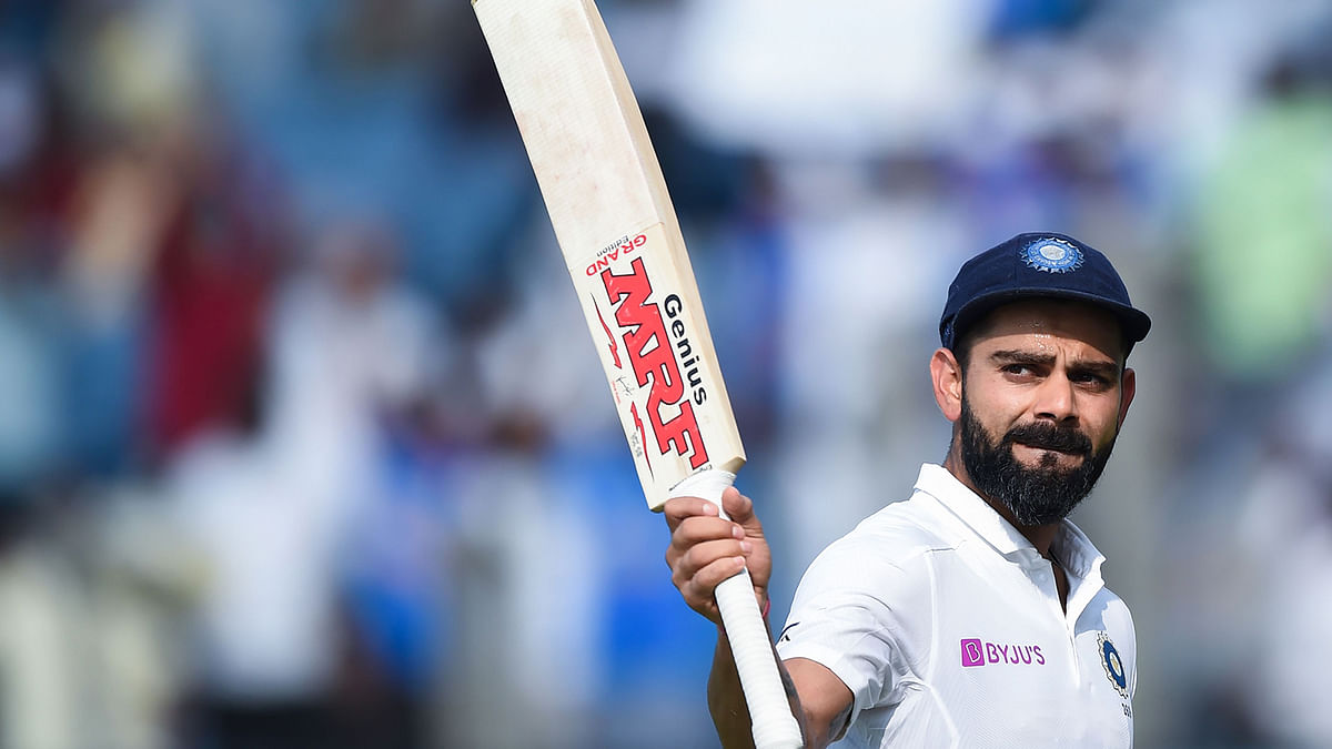 India`s cricket team captain Virat Kohli rises his bat as he leaves the field after declearing their first innings during the second day of the second Test cricket match between India and South Africa at Maharashtra Cricket Association Stadium in Pune on 11 October, 2019. Photo: AFP