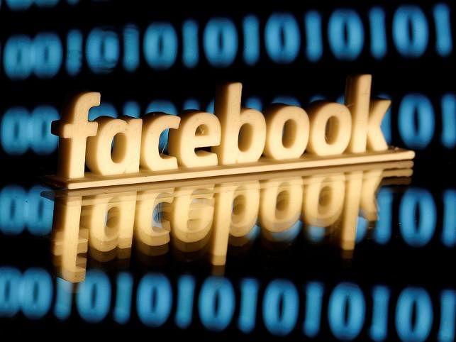 Facebook logo is seen in front of displayed binary code in this illustration picture. photo: Reuters