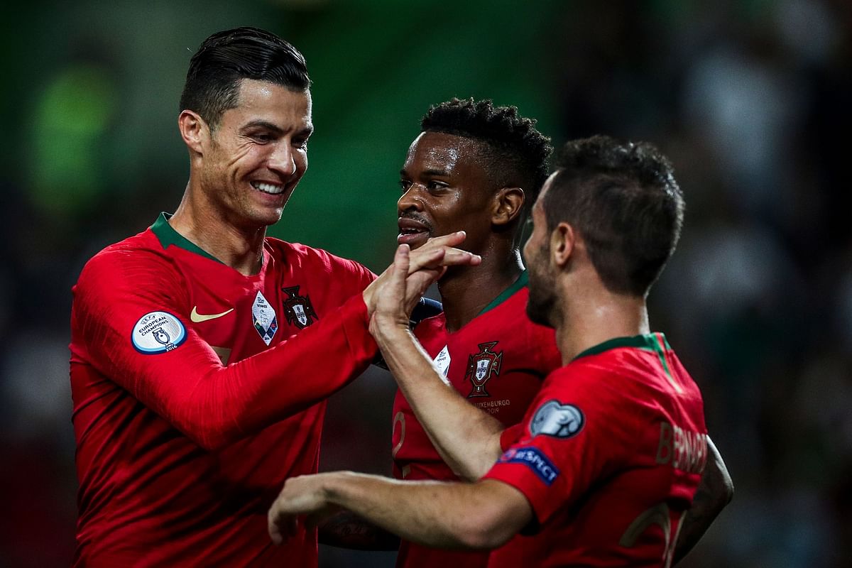 Portugal`s forward Bernardo Silva (R) celebrates with Portugal`s forward Cristiano Ronaldo (L) and Portugal`s defender Nelson Semedo (C) after scoring a goal during the Euro 2020 qualifier football match between Portugal and Luxembourg at the Jose Alvalade stadium in Lisbon on 11 October 2019. Photo: AFP