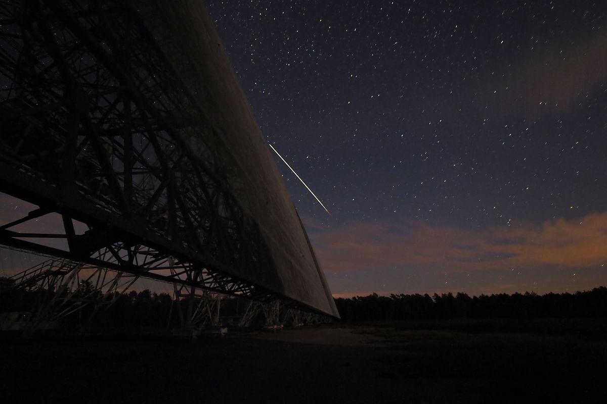 A plane crosses the sky at night over a part of the decametrique radiotelescope of Nancay, built in 1953, on 3 October 2019 in Nancay, near Vierzon, Central France. Photo: AFP