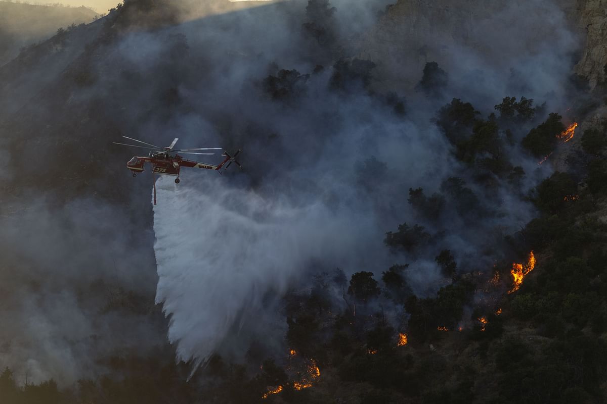 A firefighting helicopter drops water on the Saddleridge Fire on 11 October 2019 near Newhall, California. Photo: AFP