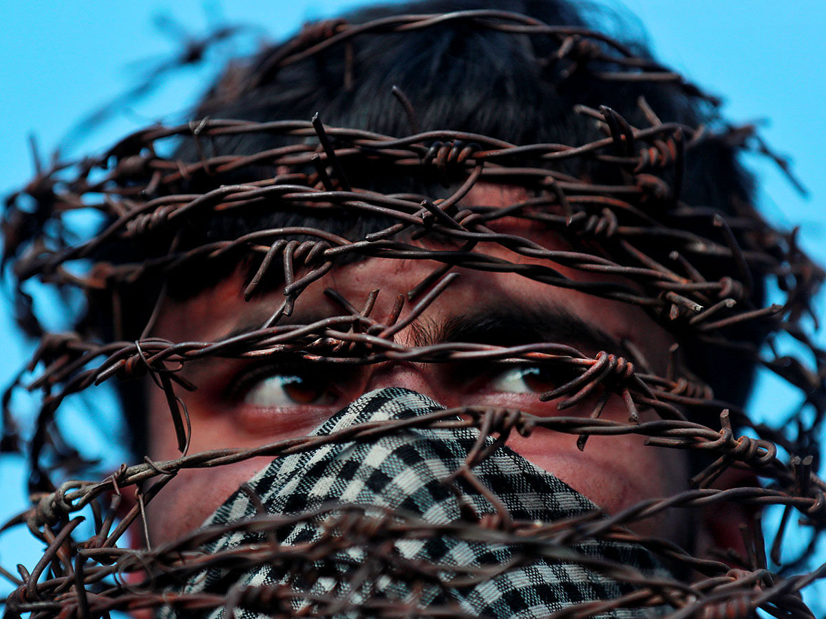 A masked Kashmiri man with his head covered with barbed wire attends a protest after Friday prayers during restrictions following the scrapping of the special constitutional status for Kashmir by the Indian government, in Srinagar, on 11 October 2019. Photo: Reuters