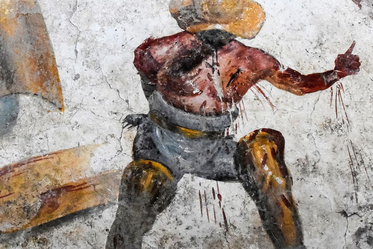 This handout picture taken on 9 October 2019 and released on 11 October 2019 by the press office of the Pompeii Archaeological Park shows a detail of a fresco depicting a heavily-armed gladiator standing victorious over his opponent gushing blood which has been discovered at Pompeii, Italy`s culture ministry said on 11 October 2019. Photo: AFP