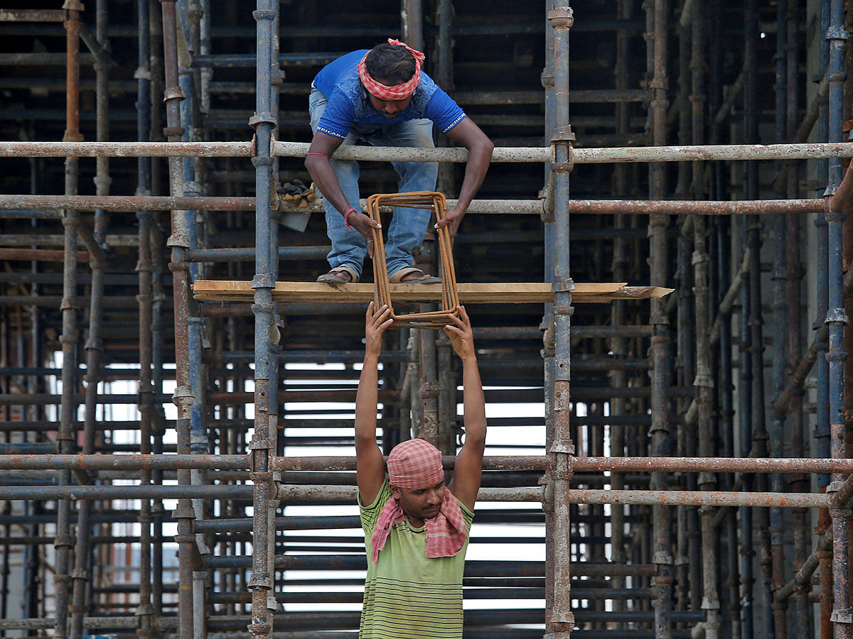 Labourers work at the construction site of a residential building on the outskirts of Kolkata, India, on 5 July 2019. Reuters File Photo