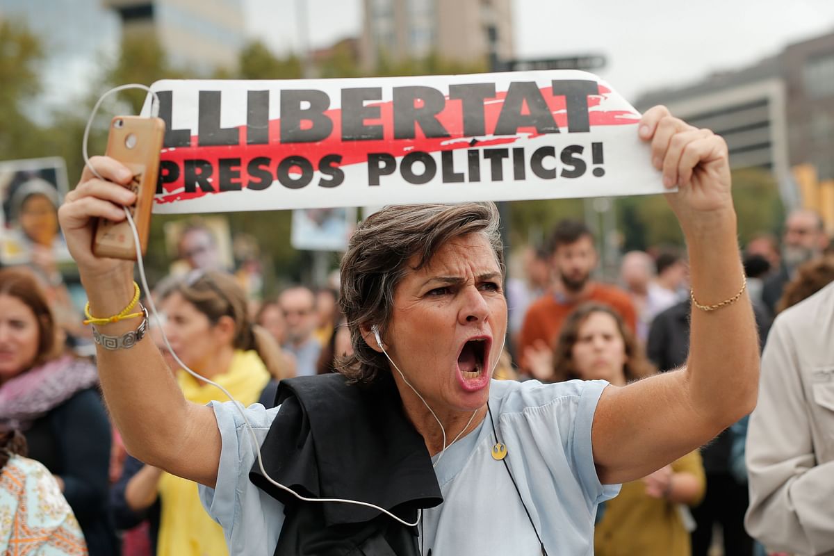 A woman shouts holding a banner `Free political prisoners` in Barcelona on 14 October 2019, after Spain`s Supreme Court sentenced nine Catalan leaders to prison terms ranging from nine to 13 years for sedition. Photo: AFP