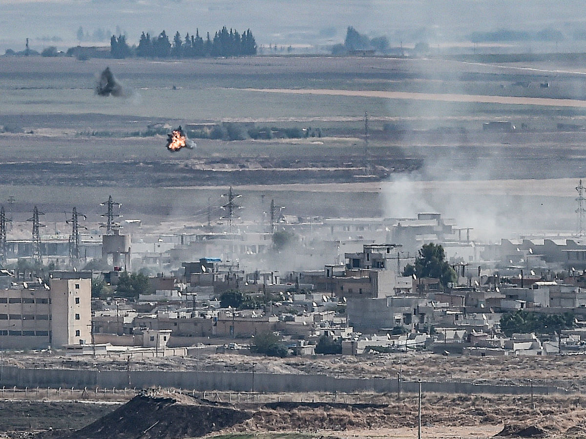 This picture taken on 13 October 2019 from the Turkish city of Ceylanpinar shows smoke rising and explosions in the Syrian border town of Ras al-Ain as fighting rages along the border on the fifth day of a Turkish offensive in Syria against the Kurdish People`s Protection Units (YPG) that has provoked an international outcry and left dozens of civilians and fighters dead. Photo: AFP
