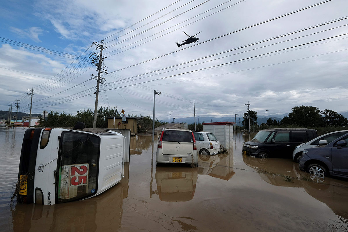 A helicopter flies over cars immersed in water in the aftermath of Typhoon Hagibis in Nagano on 14 October 2019. Tens of thousands of rescue workers were searching for survivors of powerful Typhoon Hagibis, two days after the storm slammed into Japan, killing at least 35 people. Photo: AFP