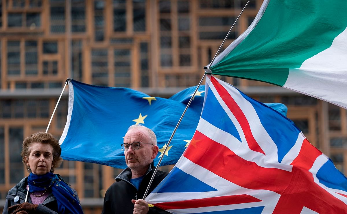 Anti-brexit activist holds European flag, United Kingdom and Irish flag in front of the EU headquarters in Brussels on 11 October 2019. Photo: AFP