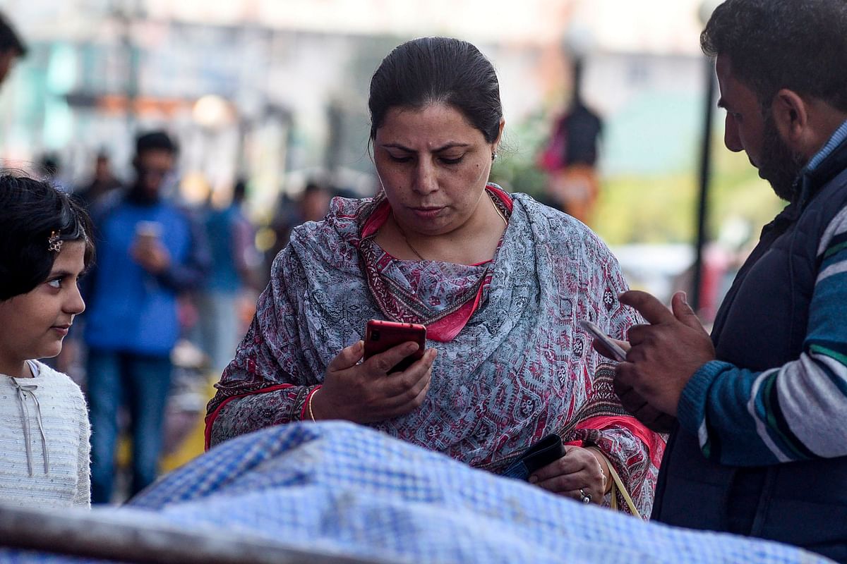 Residents use mobiles phones in Srinagar on 14 October following Indian government`s decision to restore mobile phones network in Indian-administered Kashmir. Photo: AFP
