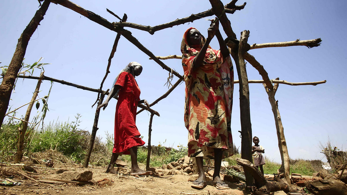 Sudanese women help build a house from tree trunks and branches on 10 October, 2019 after returning to their village of Shattaya, some 150 kms west of Niayla, the capital of Sudan`s southern Darfur region last year following more than a decade of being displaced. Photo: AFP