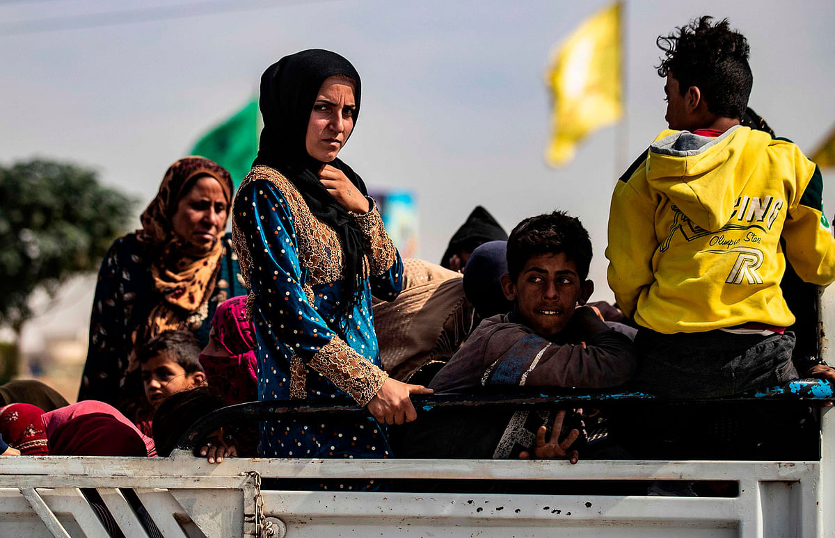 Displaced Syrians sit in the back of a pick up truck as Arab and Kurdish civilians flee amid Turkey`s military assault on Kurdish-controlled areas in northeastern Syria, on 11 October 2019 in the town of Tal Tamr in the countryside of Syria`s northeastern Hasakeh province. Photo: AFP
